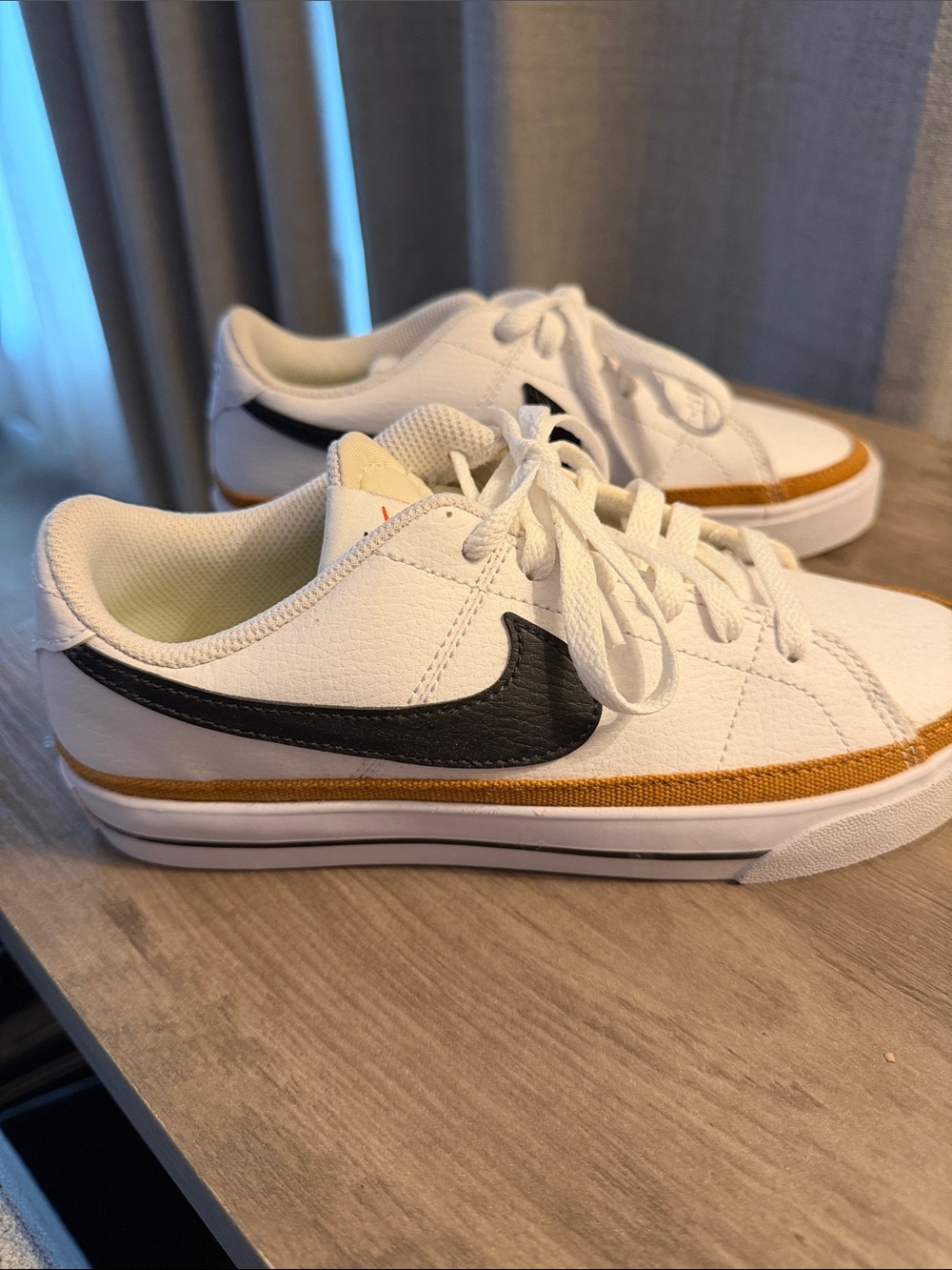 Nike White Low-Top Sneakers with Black Swoosh and Brown Accent